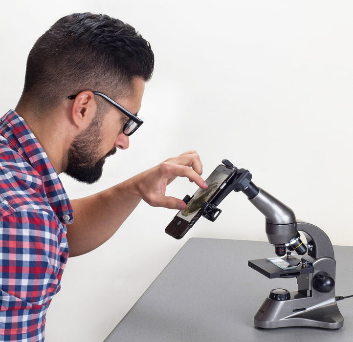 A Man Using Carson Beginner LED Biological Microscope and Smartphone Adapter