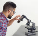 A Man Using Carson Intermediate 100x-1000x LED Compound Microscope and Smartphone Adapter