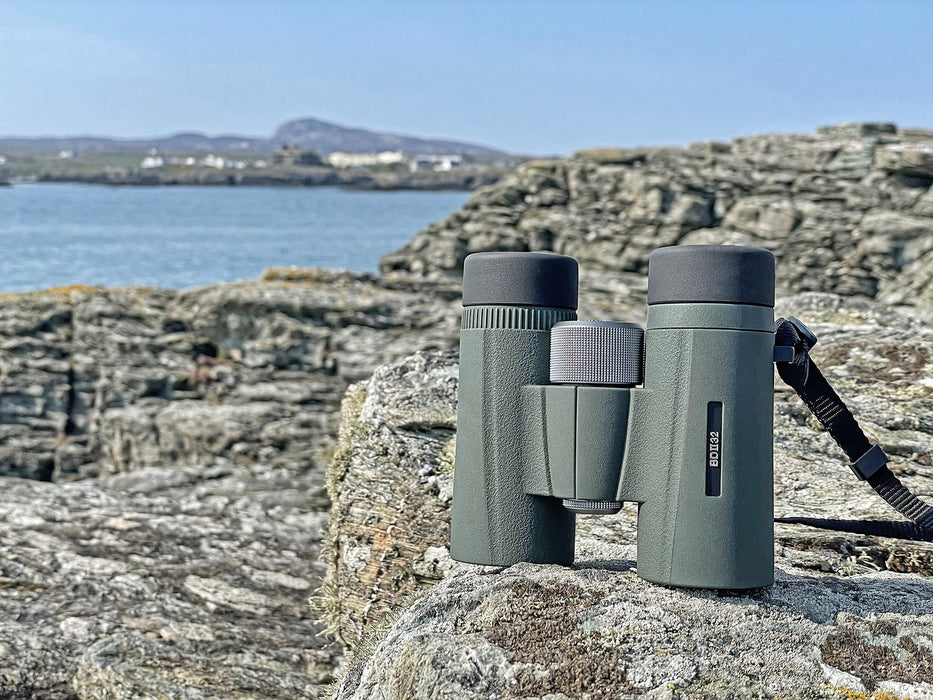 Kowa BDII-XD 10x32mm Prominar Roof Prism Wide Angle Binocular standing on a rock outdoors